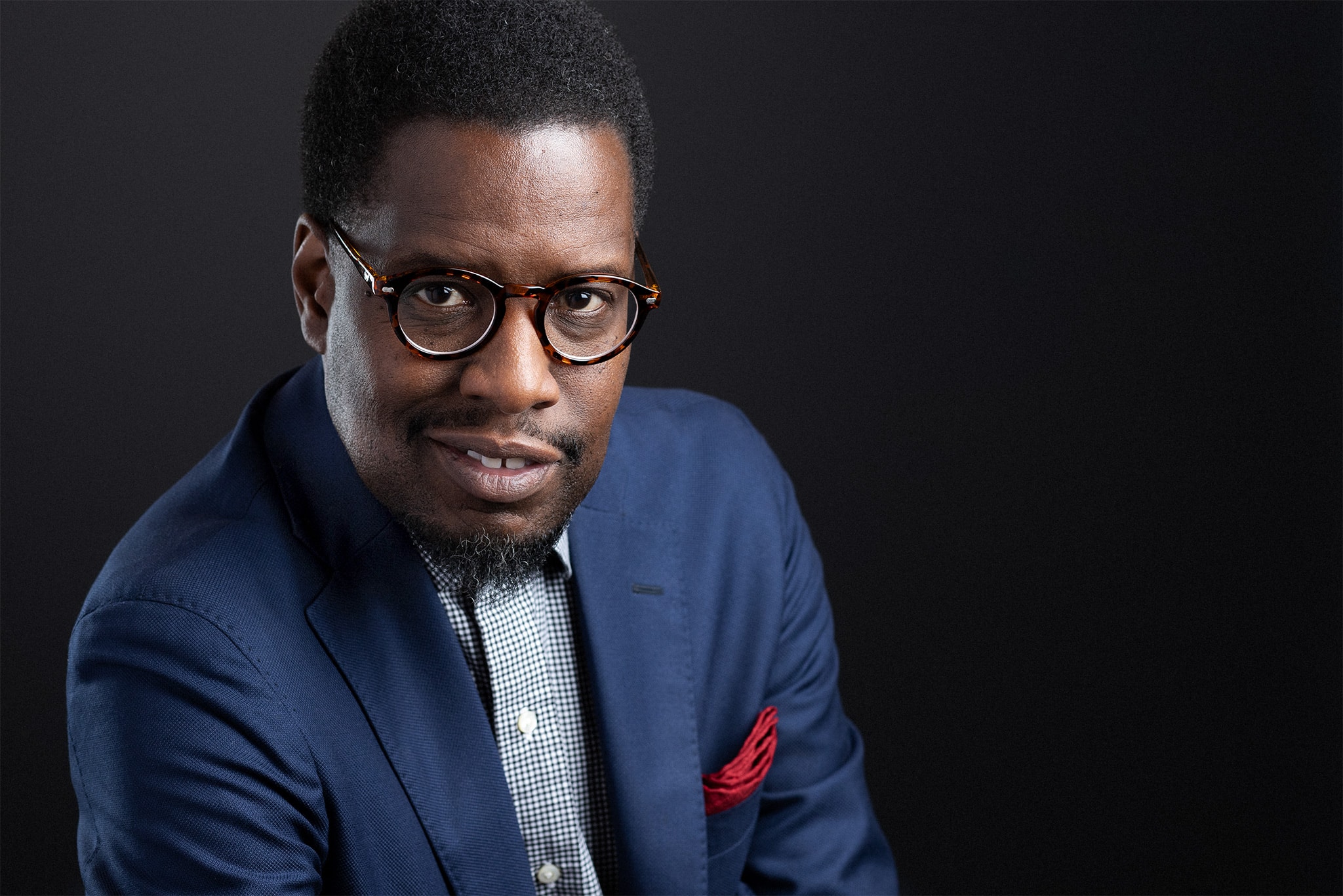 Business portrait of a handsome black man with glasses and blue suit jacket