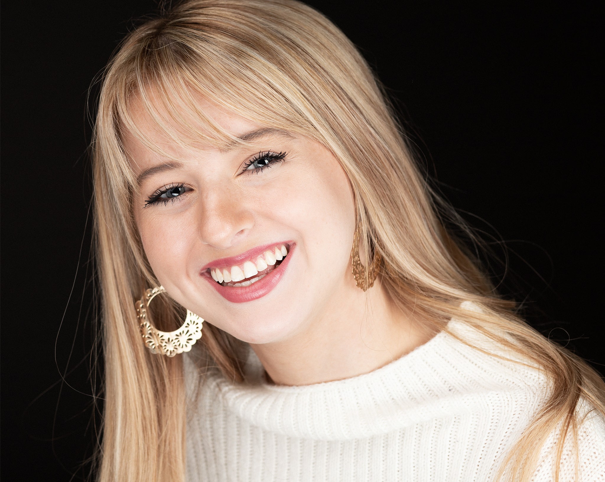 Business headshot of a beautiful young blond girl with a big smile